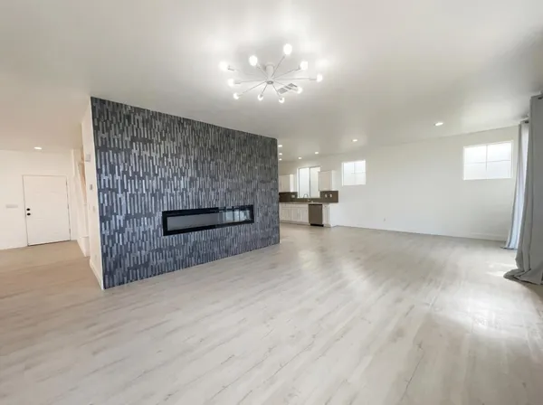 an empty room with wooden floor and fan