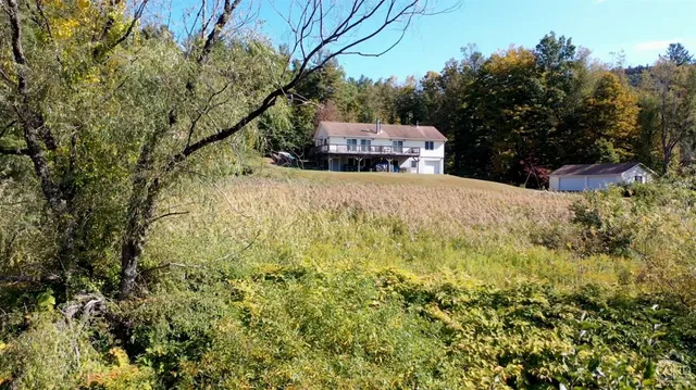 a yellow house with trees in front of it