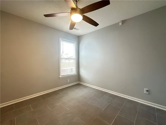 an empty room with a window and a fan