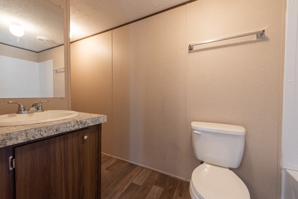 24731 County Road 340 Mathis, TX 78368 - Photo 24 of 40 a bathroom with a granite countertop sink a toilet and a mirror