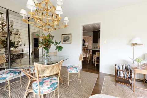 a living room with furniture a dining table and a chandelier