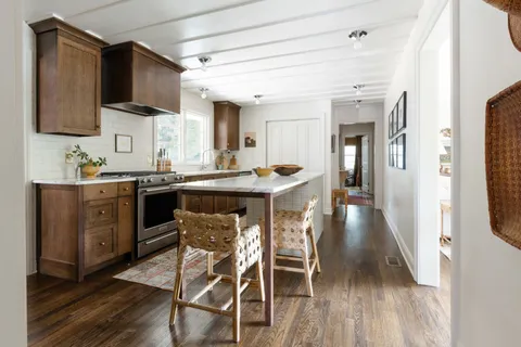 a kitchen with stainless steel appliances a table chairs refrigerator and microwave