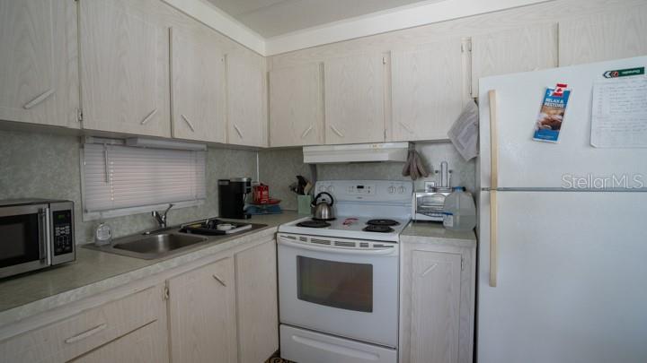 3301 Alt 19 Palm Harbor, Unit 317 Palm Harbor, FL 34683 - Photo 6 of 48 a kitchen with a sink a stove and cabinets