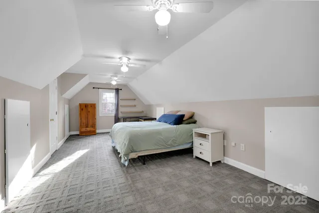a spacious bedroom with a bed and a chandelier