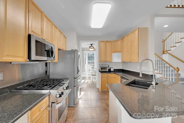 a kitchen with stainless steel appliances granite countertop a sink stove and cabinets
