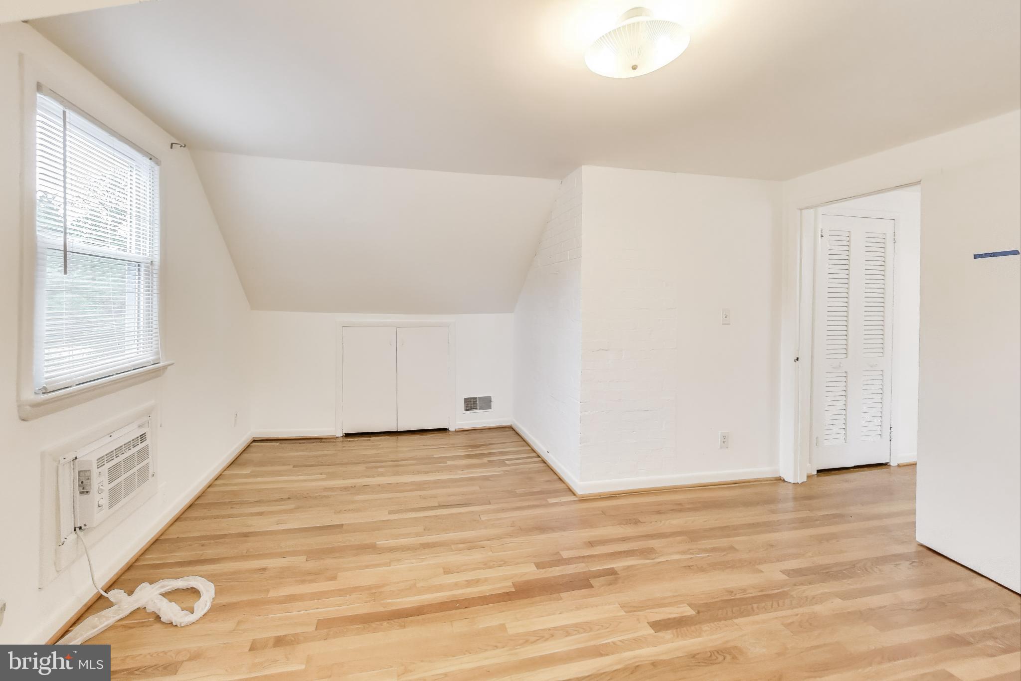 10019 Greenock Road Silver Spring, MD 20901 - Photo 21 of 39 a view of an empty room with wooden floor and a window