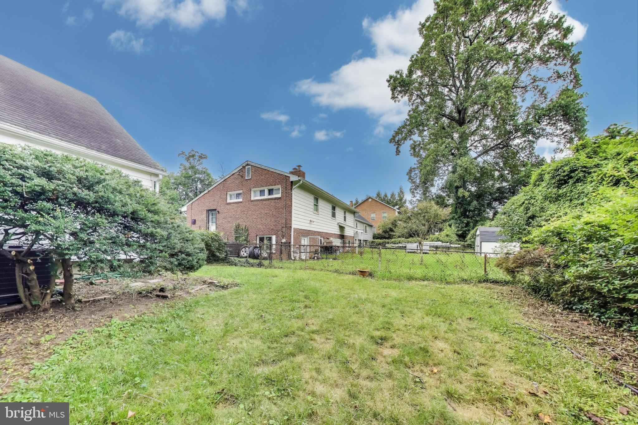 10019 Greenock Road Silver Spring, MD 20901 - Photo 39 of 39 a yellow and red house with a big yard and large trees