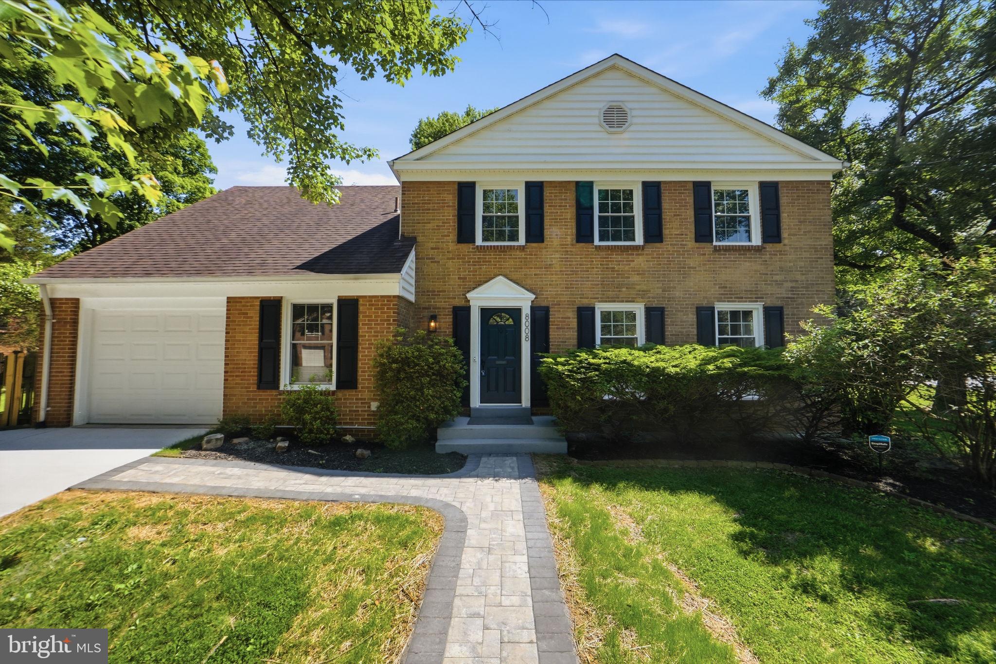 Charming brick home with lush greenery.