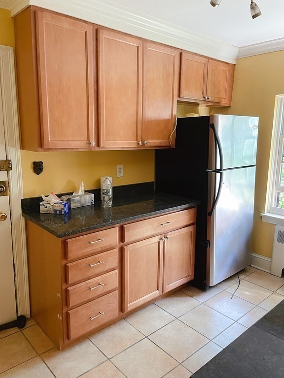 a kitchen with granite countertop a refrigerator a sink a stove and cabinets