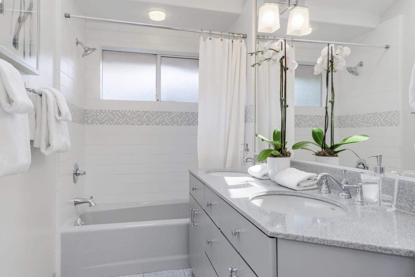 714 Arroyo Road Los Altos, CA 94024 - Photo 32 of 42 a bathroom with a granite countertop sink a mirror a bathtub and shower
