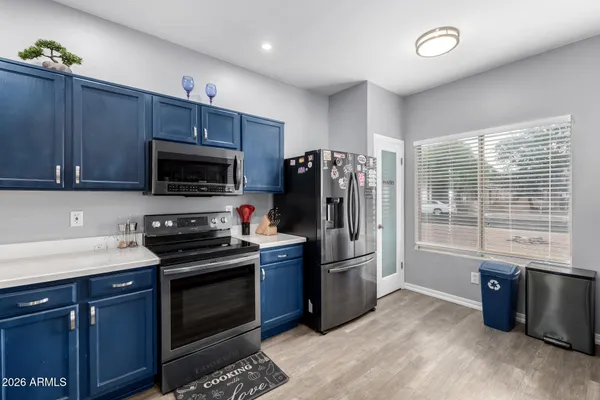 a kitchen with stainless steel appliances a stove a sink a refrigerator cabinets and a window