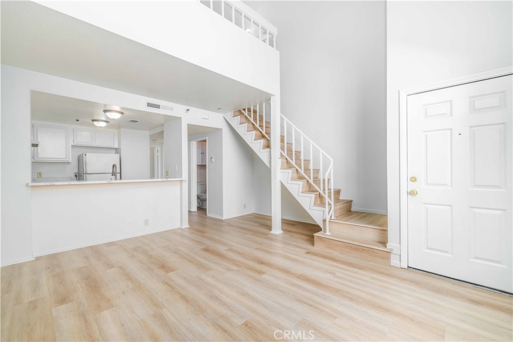 a view of staircase and kitchen with wooden floor