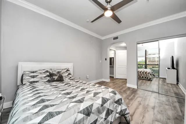 a bedroom with a large bed and a chandelier fan