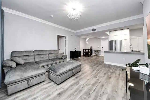 a living room with furniture and a dining table with kitchen view