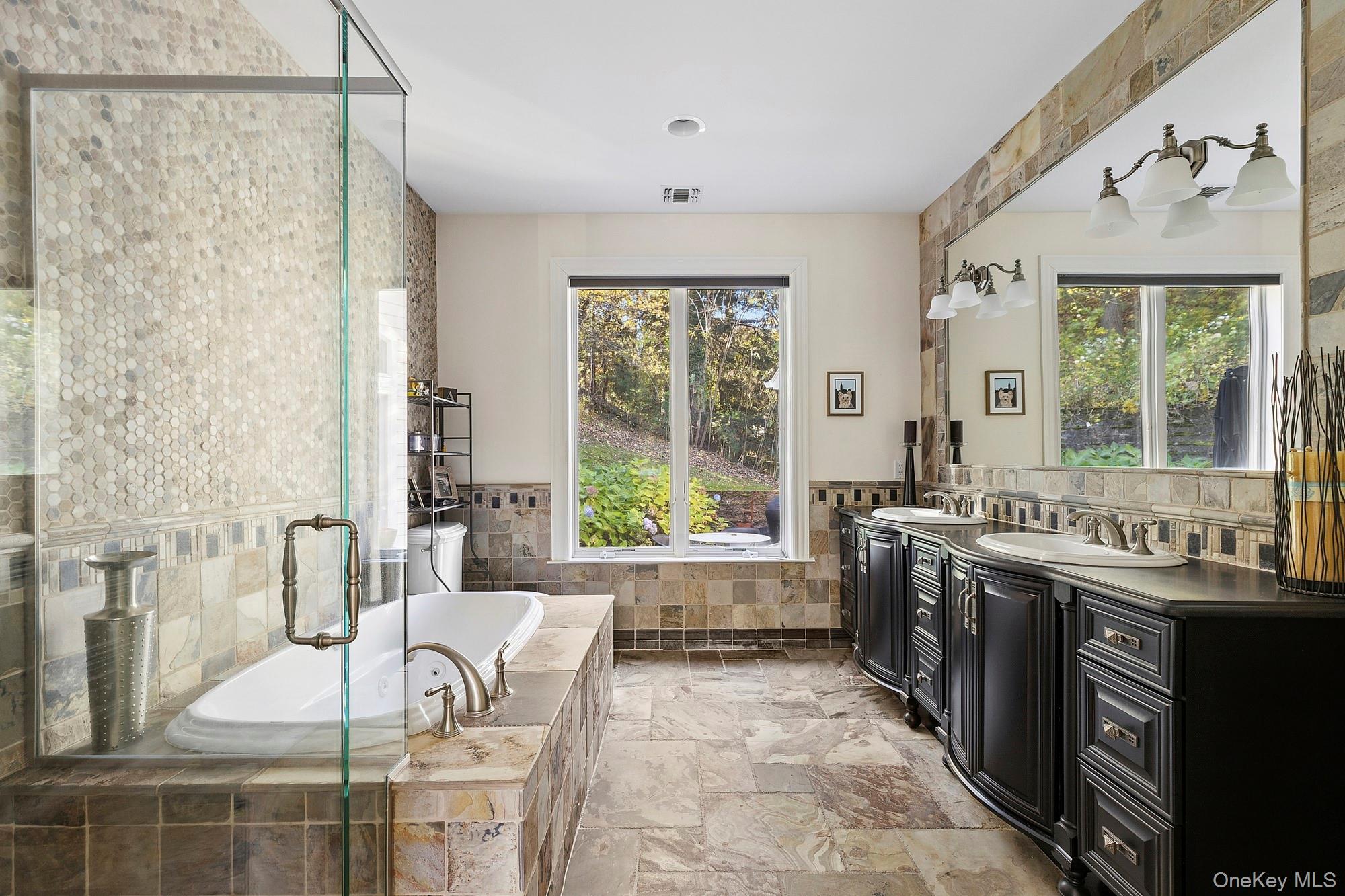 144 Round Swamp Road West Hills, NY 11743 - Photo 28 of 39 Bathroom with healthy amount of natural light, tile walls, double vanity, a bath, and a wainscoted wall