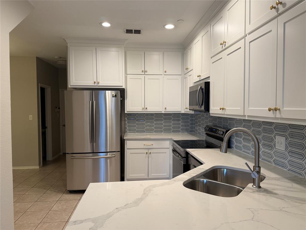 3109 Bonsai Drive Plano, TX 75093 - Photo 4 of 25 a kitchen with granite countertop a sink and stainless steel appliances