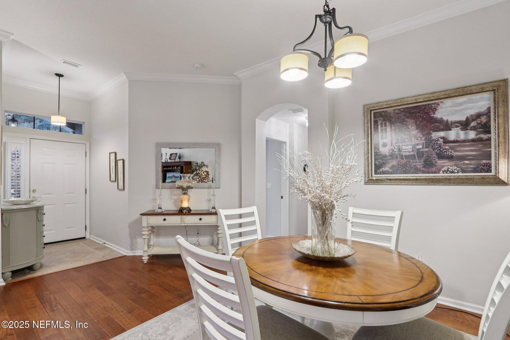 1870 Copper Stone Drive, Unit F Fleming Island, FL 32003 - Photo 14 of 36 a dining room with wooden floor a chandelier a wooden table and chairs