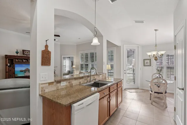 a dining hall with stainless steel appliances granite countertop a sink and cabinets