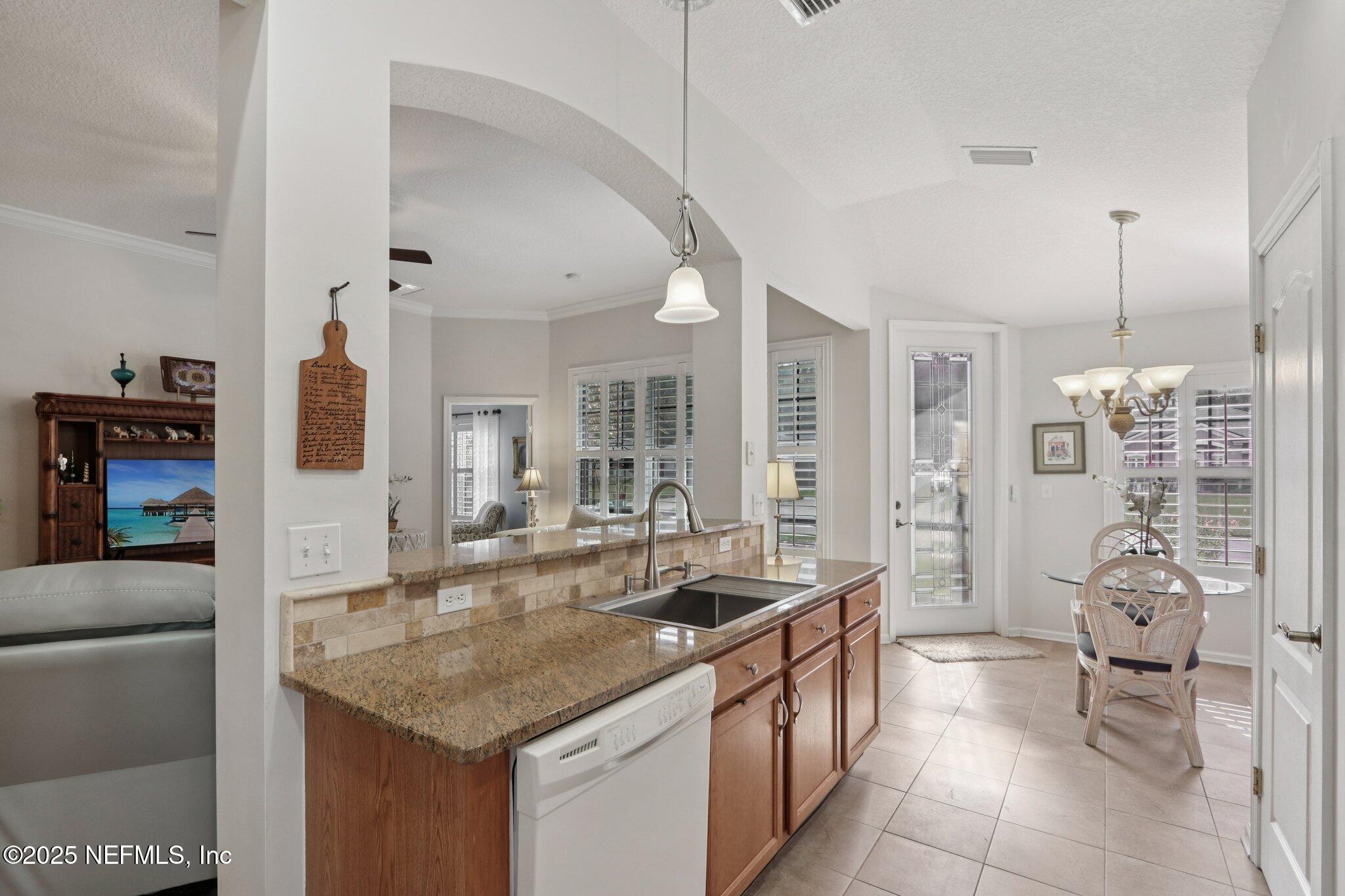 1870 Copper Stone Drive, Unit F Fleming Island, FL 32003 - Photo 19 of 36 a dining hall with stainless steel appliances granite countertop a sink and cabinets