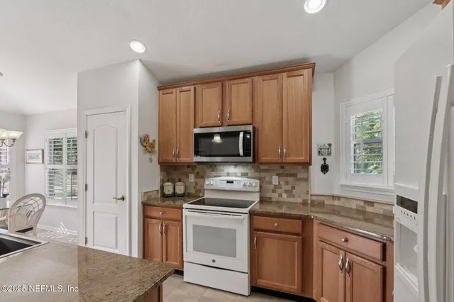 a kitchen with white cabinets sink and stainless steel appliances