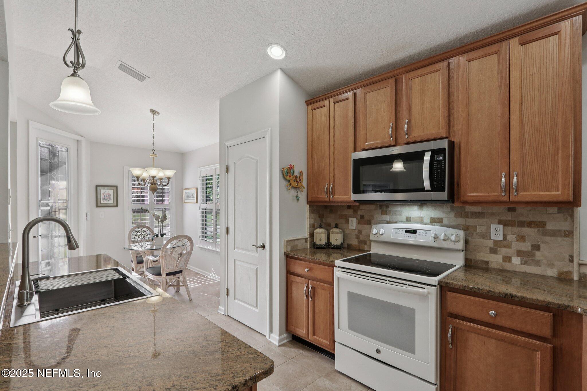1870 Copper Stone Drive, Unit F Fleming Island, FL 32003 - Photo 21 of 36 a kitchen with a sink stove and microwave