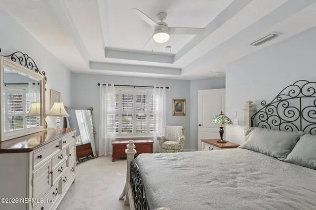 a bedroom with a large bed and wooden floor