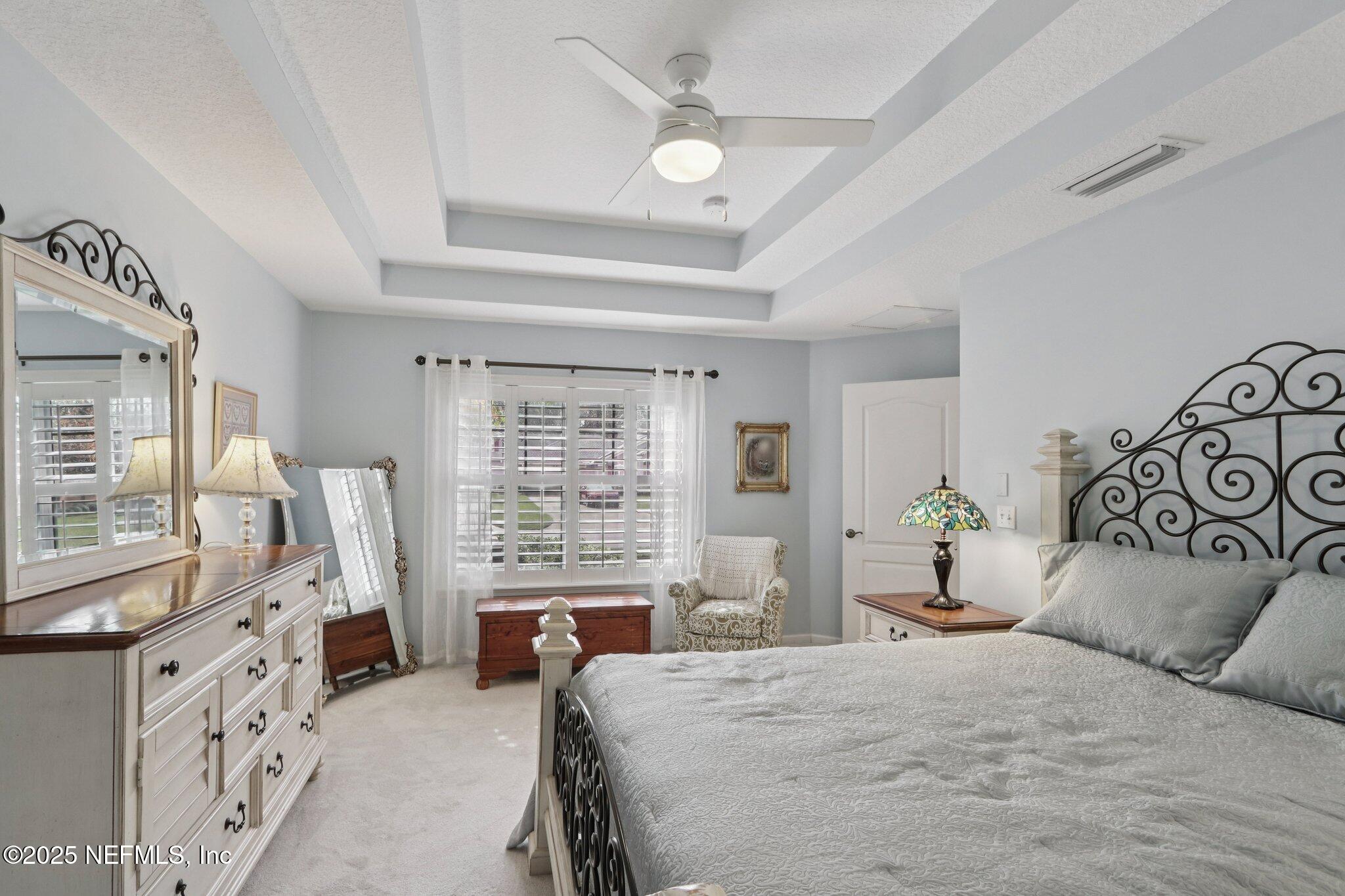 1870 Copper Stone Drive, Unit F Fleming Island, FL 32003 - Photo 28 of 36 a bedroom with a large bed and wooden floor