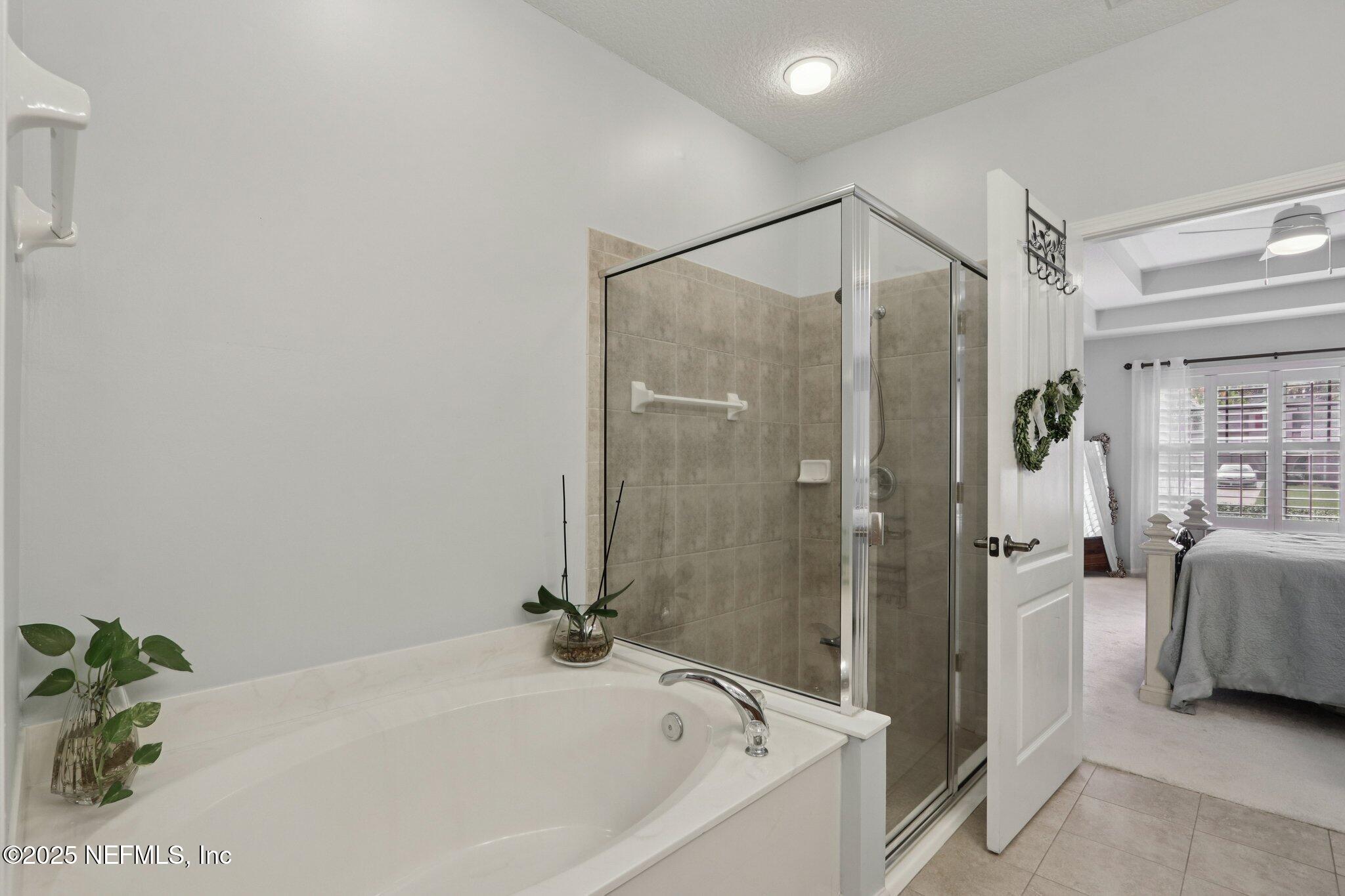 1870 Copper Stone Drive, Unit F Fleming Island, FL 32003 - Photo 30 of 36 a bathroom with a tub and shower