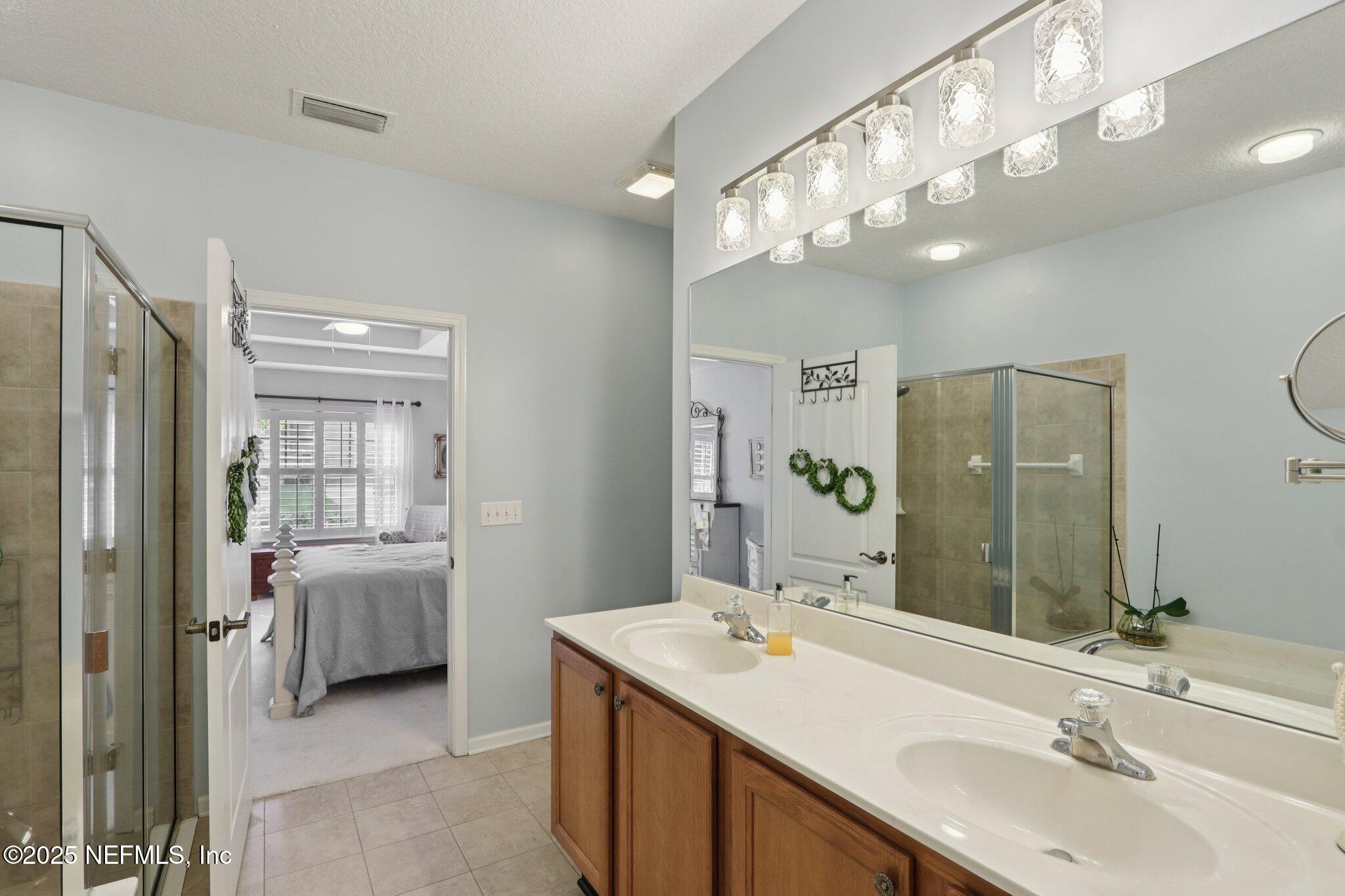 1870 Copper Stone Drive, Unit F Fleming Island, FL 32003 - Photo 31 of 36 a bathroom with a sink double vanity and a mirror