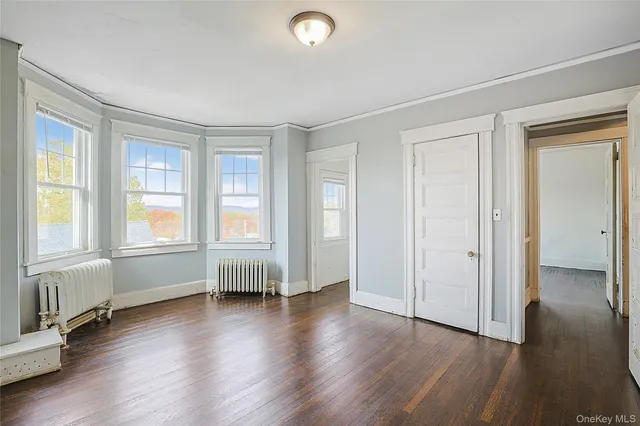 wooden floor in an empty room with a window