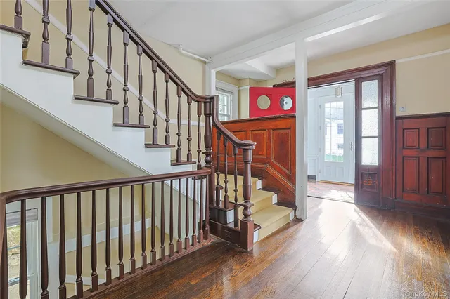 an empty room with wooden floor fireplace and windows