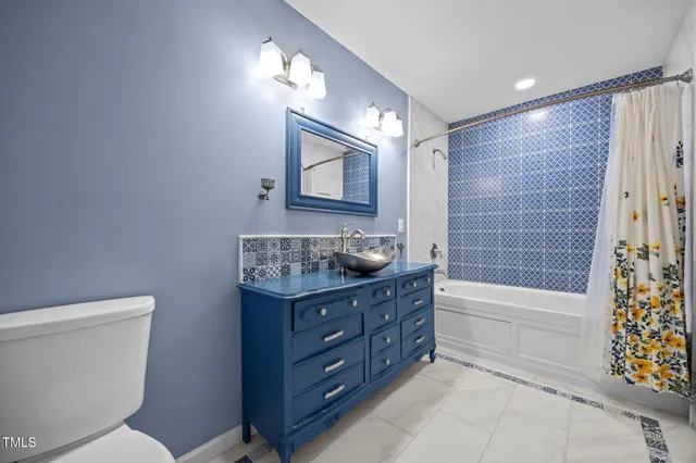 a bathroom with a granite countertop toilet a sink and bathtub