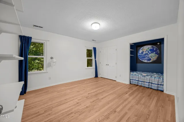 a bedroom with a bed and a painting on the wall