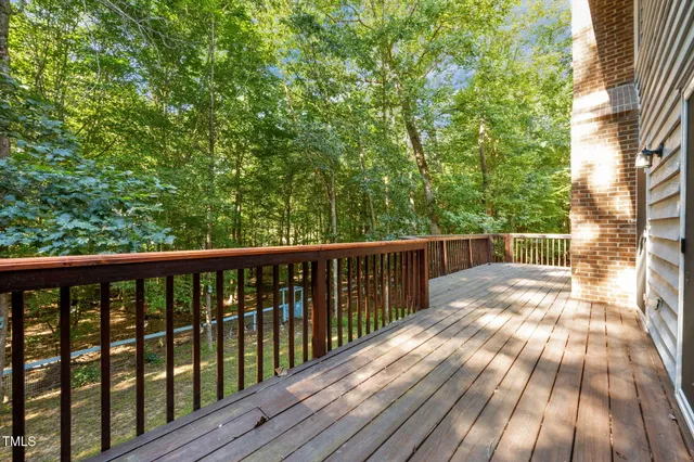 a balcony with wooden floor and fence