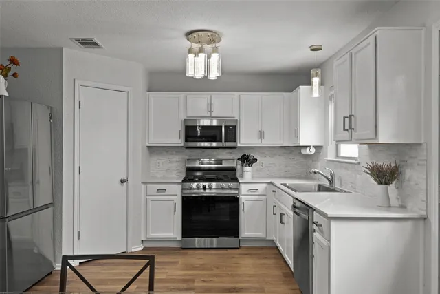 a kitchen with cabinets stainless steel appliances and a counter space