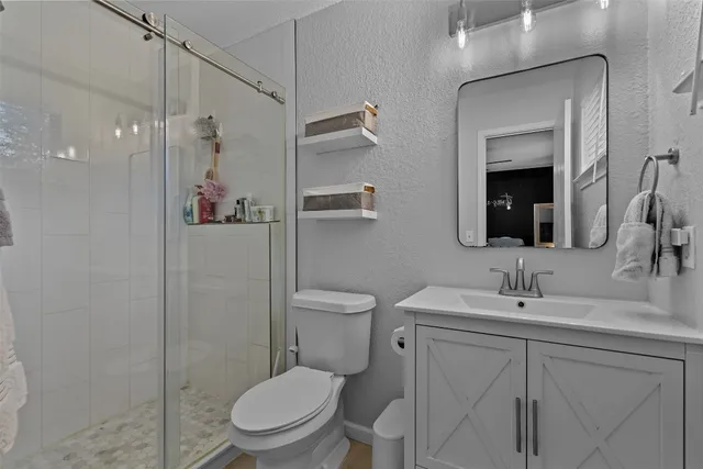 a bathroom with a toilet sink vanity and mirror