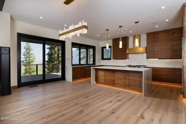 a large kitchen with stainless steel appliances granite countertop a large oven a stove and a wooden floors