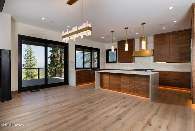 a large kitchen with stainless steel appliances granite countertop a large oven a stove and a wooden floors