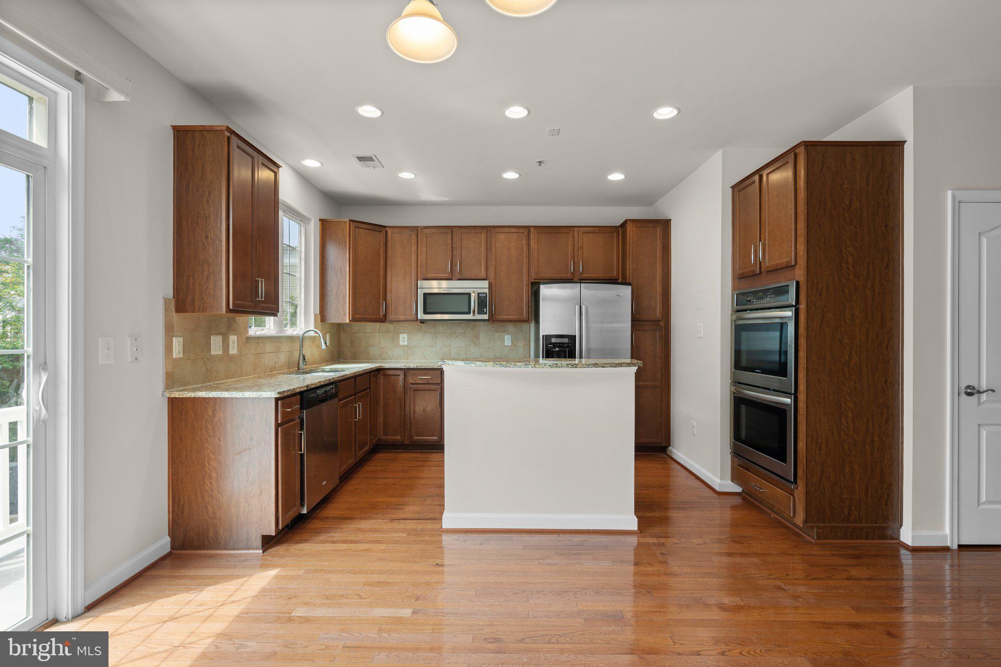 11669 Leesborough Circle Silver Spring, MD 20902 - Photo 11 of 46 a large kitchen with stainless steel appliances granite countertop a refrigerator and a stove top oven