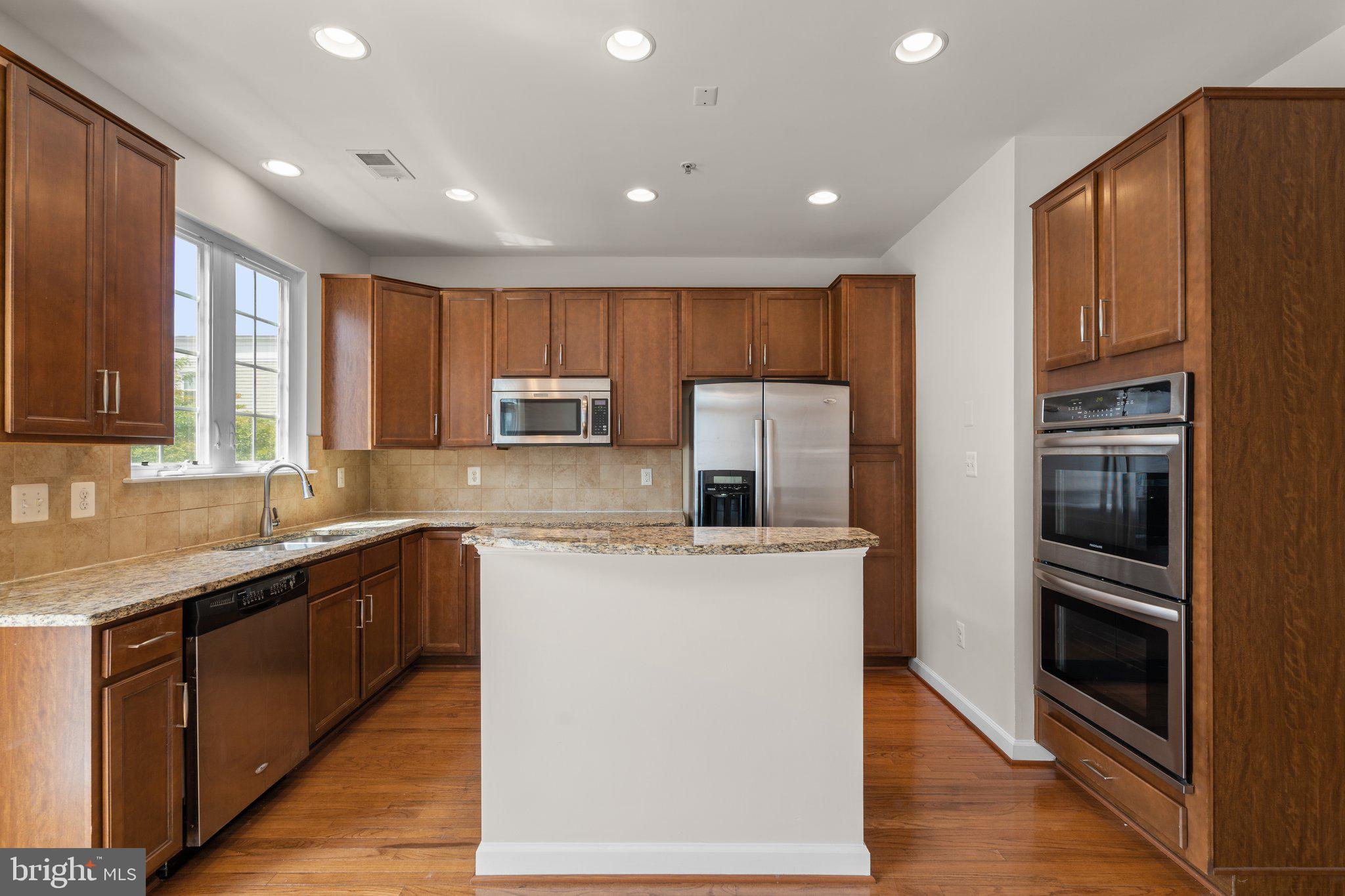 11669 Leesborough Circle Silver Spring, MD 20902 - Photo 12 of 46 a kitchen with stainless steel appliances granite countertop a refrigerator a stove a sink and a microwave