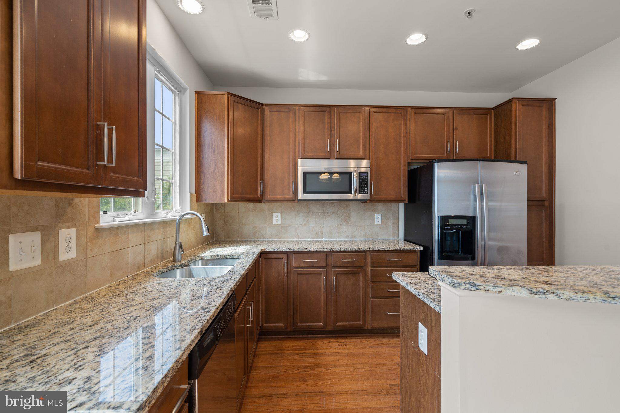 11669 Leesborough Circle Silver Spring, MD 20902 - Photo 17 of 46 a kitchen with kitchen island granite countertop stainless steel appliances and a counter top space