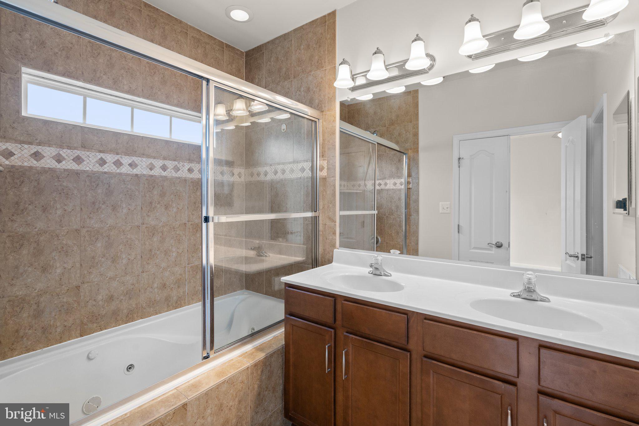 11669 Leesborough Circle Silver Spring, MD 20902 - Photo 23 of 46 a bathroom with a sink vanity tub and a shower