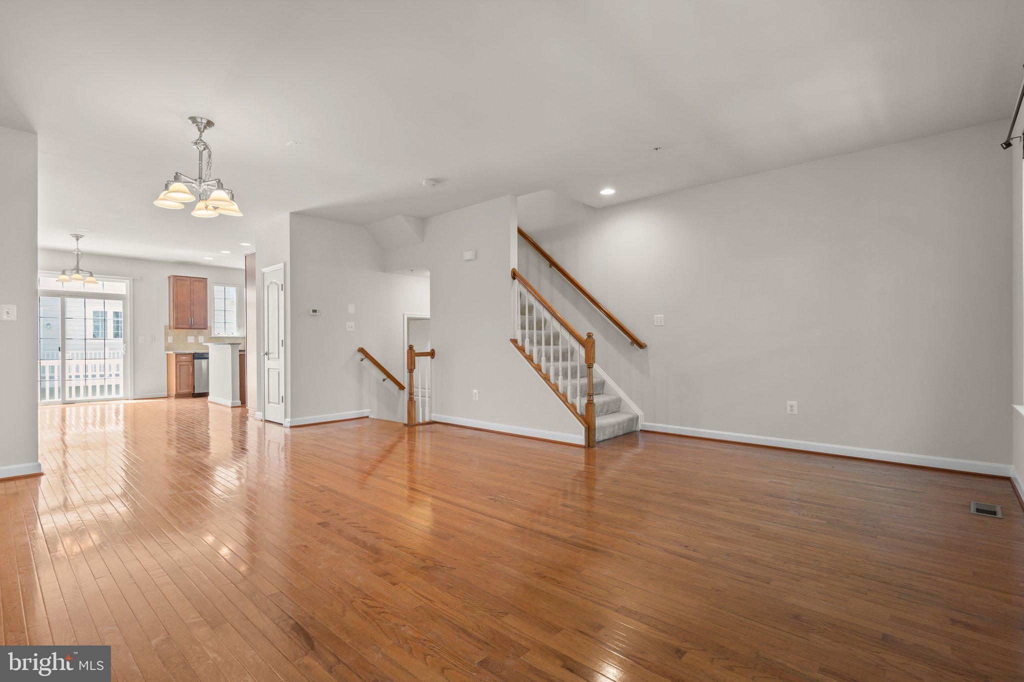 11669 Leesborough Circle Silver Spring, MD 20902 - Photo 46 of 46 a view of an empty room with wooden floor and a chandelier