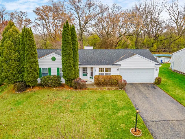 a front view of a house with a yard and trees