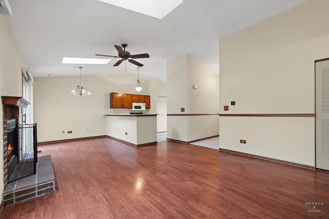 a view of a kitchen with wooden floor and a ceiling fan