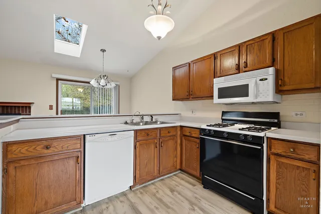a kitchen with stainless steel appliances granite countertop wooden cabinets stove top oven and sink