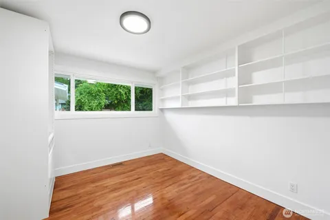 a view of a room with wooden floor and fan