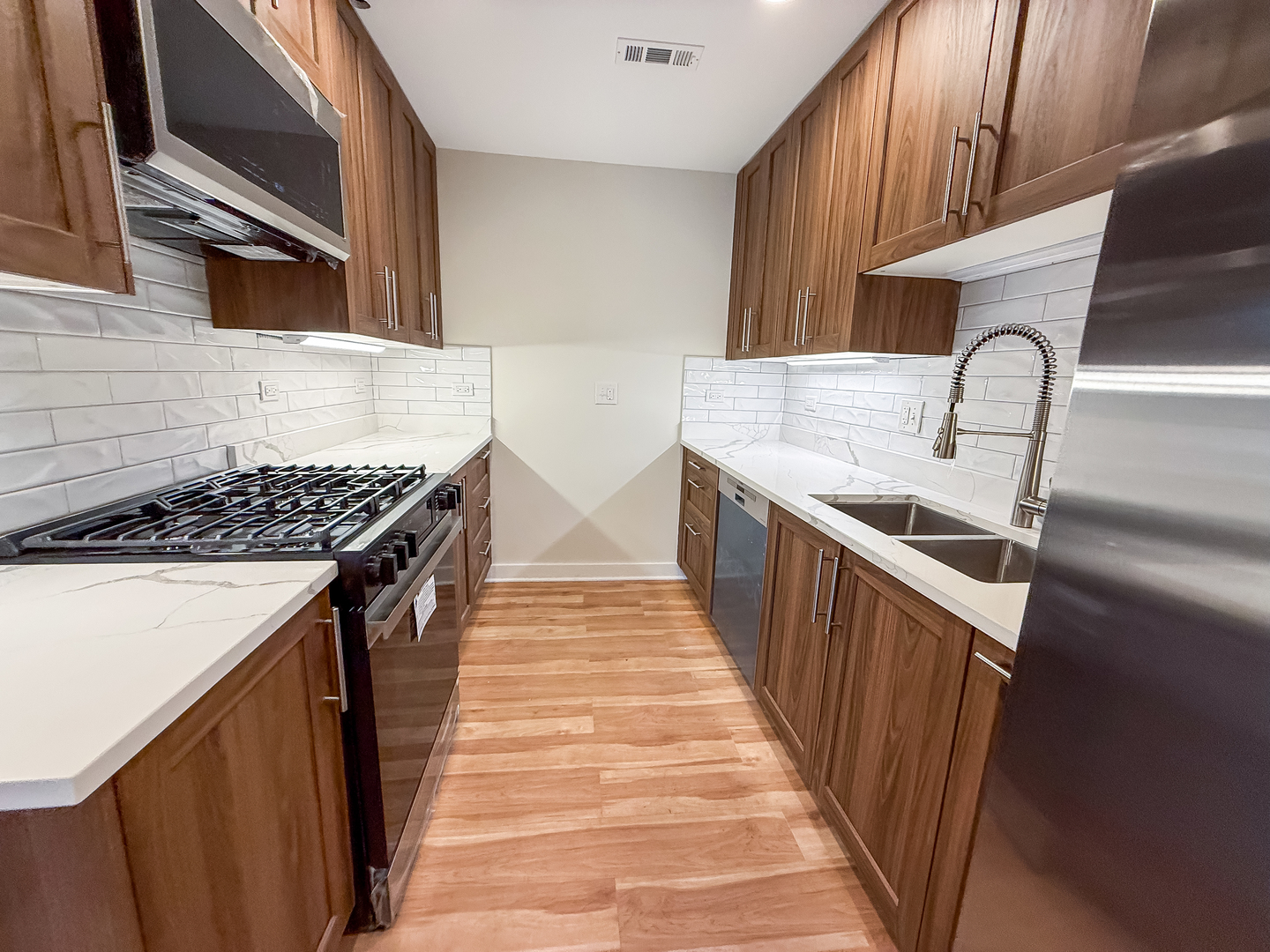6415 West Irving Park Road, Unit 2S Chicago, IL 60634 - Photo 2 of 11 a kitchen with stainless steel appliances granite countertop a stove and a sink