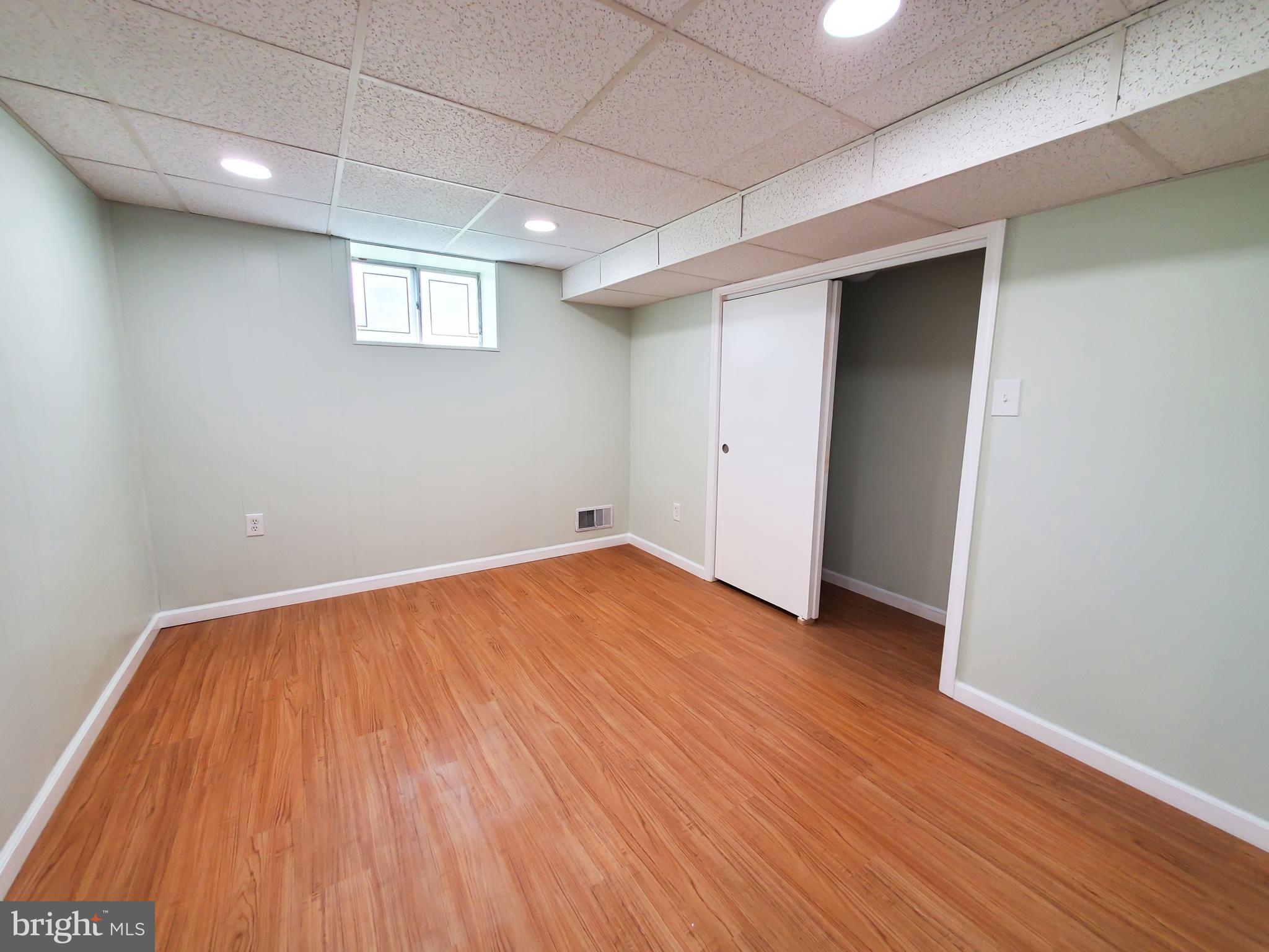 1512 Customs Road Baltimore, MD 21237 - Photo 29 of 43 an empty room with wooden floor and windows