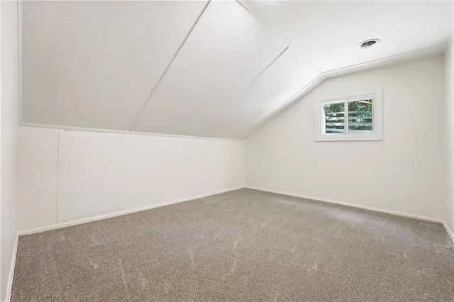 a view of an empty room with window and closet